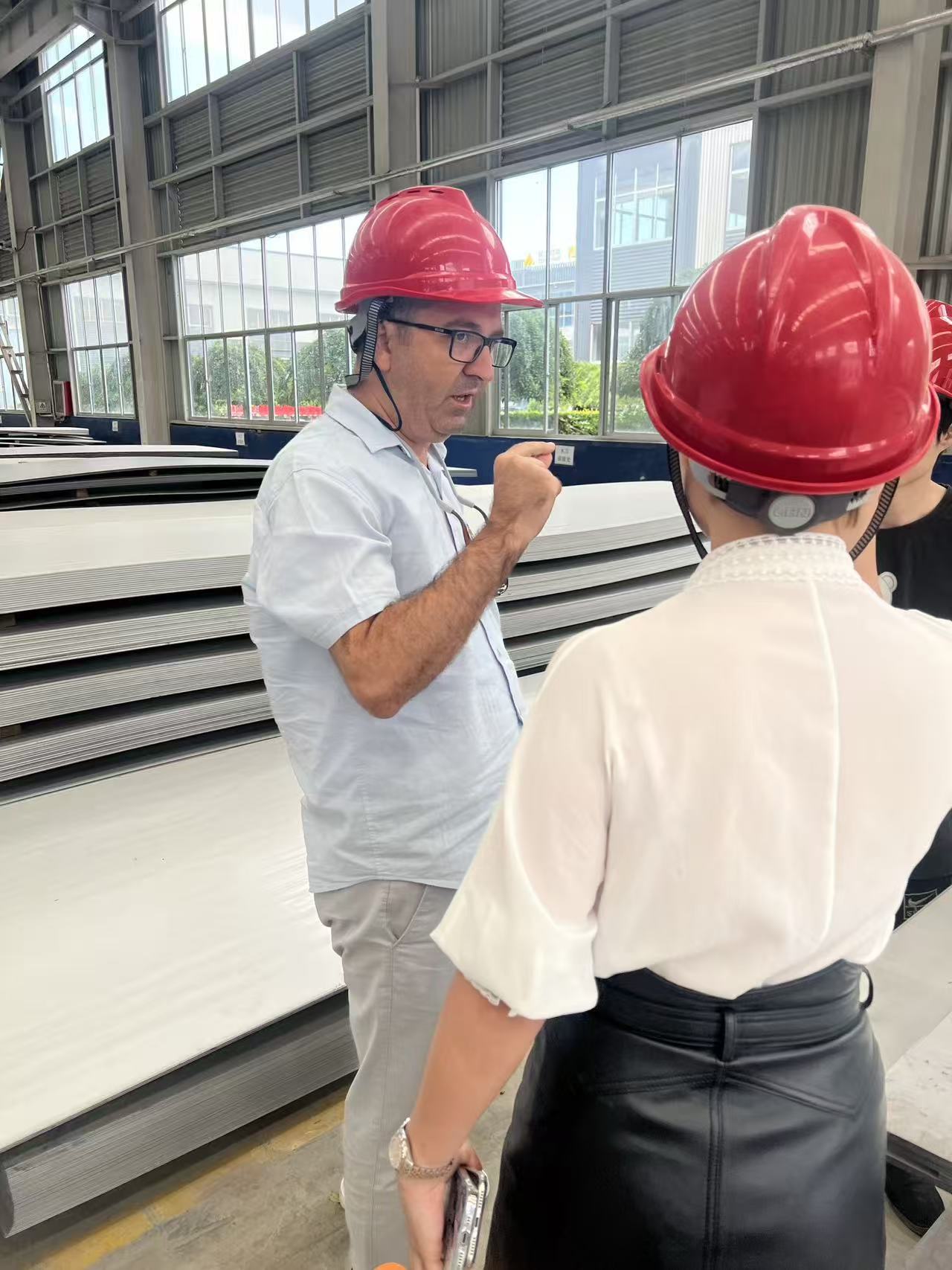 Customer checking steel sheet thickness during factory visit